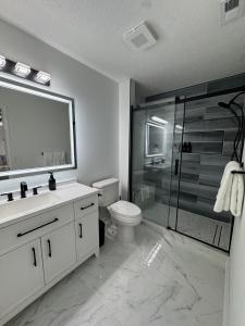 a bathroom with a shower and a toilet and a sink at Sunset Beachside Getaway, 6 mins WALK to the Beach in Panama City Beach +86 photos