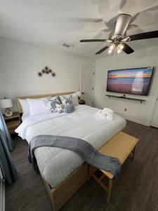 a bedroom with a large bed with a ceiling fan at Sunset Beachside Getaway, 6 mins WALK to the Beach in Panama City Beach