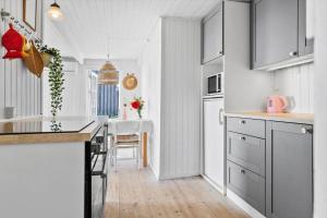 a kitchen with white cabinets and a table in it at 30553-Odder-Toldvejen-45-F in Odder