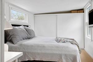 a white bedroom with a bed with a window at 40162-Juelsminde-Gludvej-9 in Juelsminde +28 photos