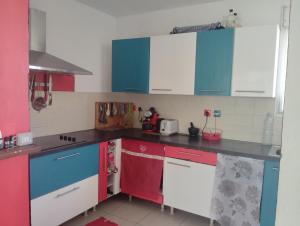 a kitchen with blue and red cabinets in a room at La chambre zen in Saint-André