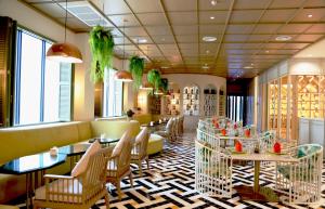 a restaurant with tables and chairs and windows at Savan Resorts in Savannakhet