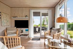 a living room with a table and chairs and a television at 30401-Odder-Stakket-Torn-12 in Odder
