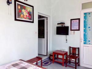 a bedroom with a bed and two chairs and a television at Khách sạn Hải Âu - Phố đi bộ Cô Tô in Gow Tow