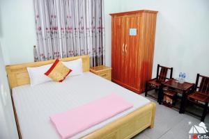 a bedroom with a bed and a wooden cabinet at Khách sạn Hải Âu - Phố đi bộ Cô Tô in Gow Tow