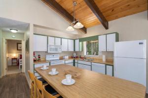 a kitchen with a wooden table and a white refrigerator at Maple Leaf Lodge by NW Comfy Cabins in Leavenworth