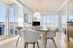 a dining room with white chairs and a table at 40100-Juelsminde-Strandengen-32 in Juelsminde
