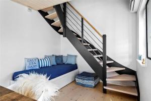 a room with a blue couch under a staircase at 40100-Juelsminde-Strandengen-32 in Juelsminde +34 photos