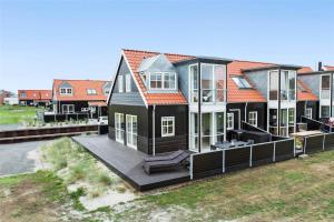 a large black house with a large deck at 40100-Juelsminde-Strandengen-32 in Juelsminde