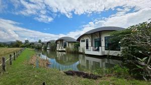 a row of cottages next to a river at Capybara Zen Resort And Spa in Ban Mae Pong +41 photos