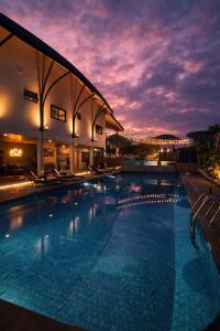 a large swimming pool with a sunset in the background at Capybara Zen Resort And Spa in Ban Mae Pong