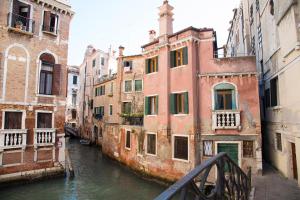 un pont sur un canal dans une ville avec des bâtiments dans l'établissement Charming Venice Apartments, à Venise