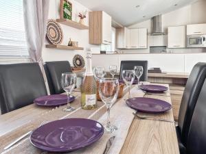 a wooden table with purple plates and wine glasses at Sunset Lodge in Lancaster
