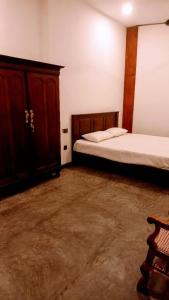 a bedroom with two beds and a wooden cabinet at Ahangama Wave Nook in Ahangama