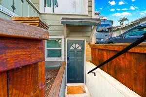 a house with a wooden fence with a door at Netflix, Stocked Kitchenette, Beach Gear in Ventura