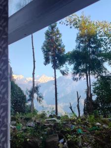 a view of trees and mountains from a window at Hotel Silver Cloud in Pelling