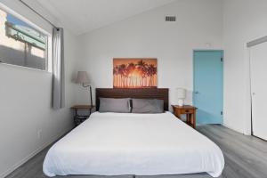 a bedroom with a white bed and a window at Ocean View Beach Stay w Pool Table & Bikes in Oxnard