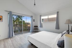 a bedroom with a bed and a large window at Ocean View Beach Stay w Pool Table & Bikes in Oxnard