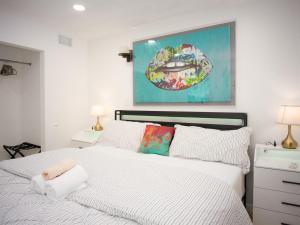 a bedroom with a white bed and a painting on the wall at Private 1BR w Yard & King Bed Simi Valley in Simi Valley