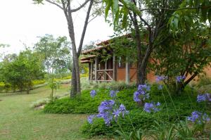 a garden with purple flowers in front of a building at Pousada Spa Prana Lorien in Santo Antônio do Leite