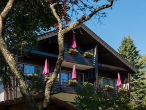 a house with pink umbrellas on the balcony at Landhaus Gruden Sommerberg in Bad Wildbad