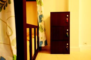 a bedroom with a bed and a dresser next to a door at Early Bird Hostel Ayutthaya in Phra Nakhon Si Ayutthaya