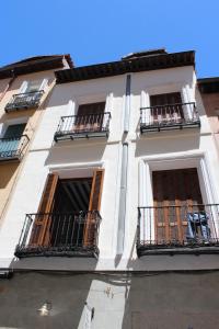 un edificio alto de color blanco con balcones y ventanas en Loft las letras, en Madrid