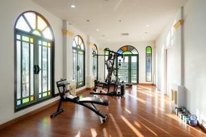 a gym with two exercise bikes in a room with windows at Cheva Gallery Boutique Hotel in Chiang Mai +14 photos