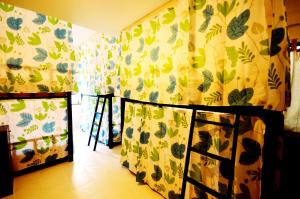 a bedroom with a bed and curtains with leaves on it at Early Bird Hostel Ayutthaya in Phra Nakhon Si Ayutthaya