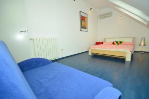 a living room with a blue couch and a bed at Hi-End Apartment in Zagreb
