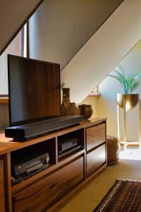 a living room with a flat screen tv on a wooden entertainment center at Edwoods Boutique Bed & Breakfast in Oamaru