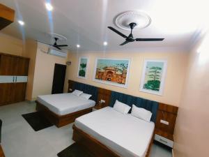 a bedroom with two beds and a ceiling fan at Hotel Orchha Heritage in Orchha