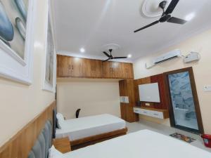 a bedroom with two beds and a ceiling fan at Hotel Orchha Heritage in Orchha +9 photos