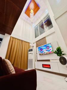 a living room with a couch and a tv at M3 Haven Masbate in Masbate
