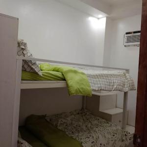 a room with two bunk beds with a green pillow at M3 Haven Masbate in Masbate +4 photos