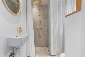 a bathroom with a shower with a sink and a mirror at 40160-Juelsminde-Hasselvej-8 in Juelsminde +32 photos