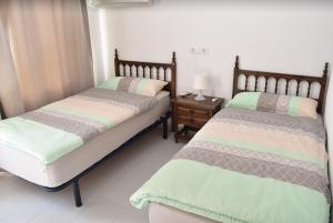 a bedroom with two beds and a night stand at Casa Blanca Suiza in Benissa