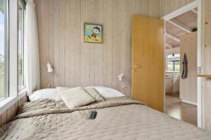 a bedroom with a bed with a remote control on it at 30536-Odder-Strandagervej-3 in Odder