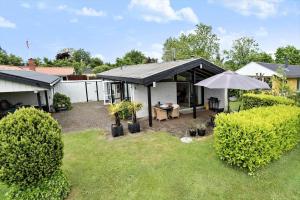 a backyard with a table and an umbrella at 30536-Odder-Strandagervej-3 in Odder