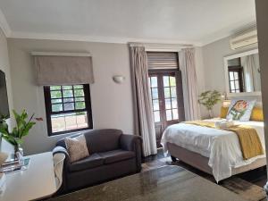 a bedroom with a bed and a couch and a chair at Studio in Central Stellenbosch in Stellenbosch