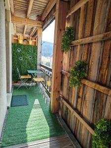 a patio with a table and a green floor at Studio Stylisé Chalet in Rochejean