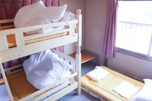 two bunk beds in a room with a window at ゲストハウスkaminn in Yoshino