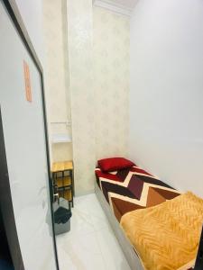 a small bedroom with a bed in a room at Mubarak Hostel Syari'ah in Bukittinggi