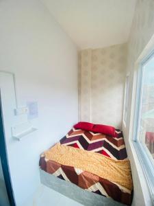 a small bed in a small room with a window at Mubarak Hostel Syari'ah in Bukittinggi