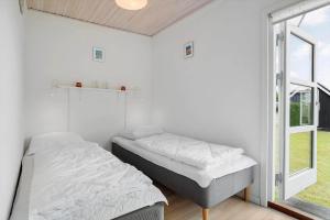 a bedroom with two beds and a window at 40606-Juelsminde-Pilevaenget-24 in Juelsminde +26 photos