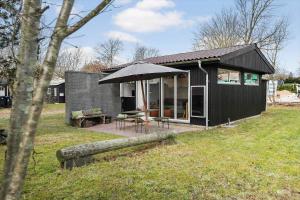 a black house with a table and an umbrella at 30325-Odder-Rythiavang-22 in Odder +16 photos