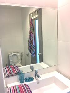 a bathroom with a sink and a mirror at Grand Blue Fantastic Pool / Sea View 1 BR unit in Mae Pim