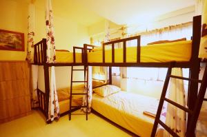 two bunk beds in a room with a bed at Early Bird Hostel Ayutthaya in Phra Nakhon Si Ayutthaya