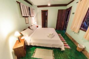 a bedroom with a white bed and a green floor at Pousada Spa Prana Lorien in Santo Antônio do Leite +37 photos