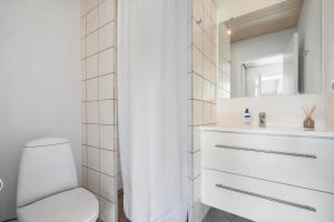 a white bathroom with a toilet and a sink at 40172-Juelsminde-Strandengen-30 in Juelsminde +39 photos